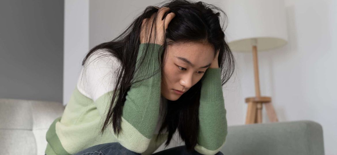 anxious-worried-asian-millennial-girl-holding-head-2023-11-27-05-27-29-utc (1)